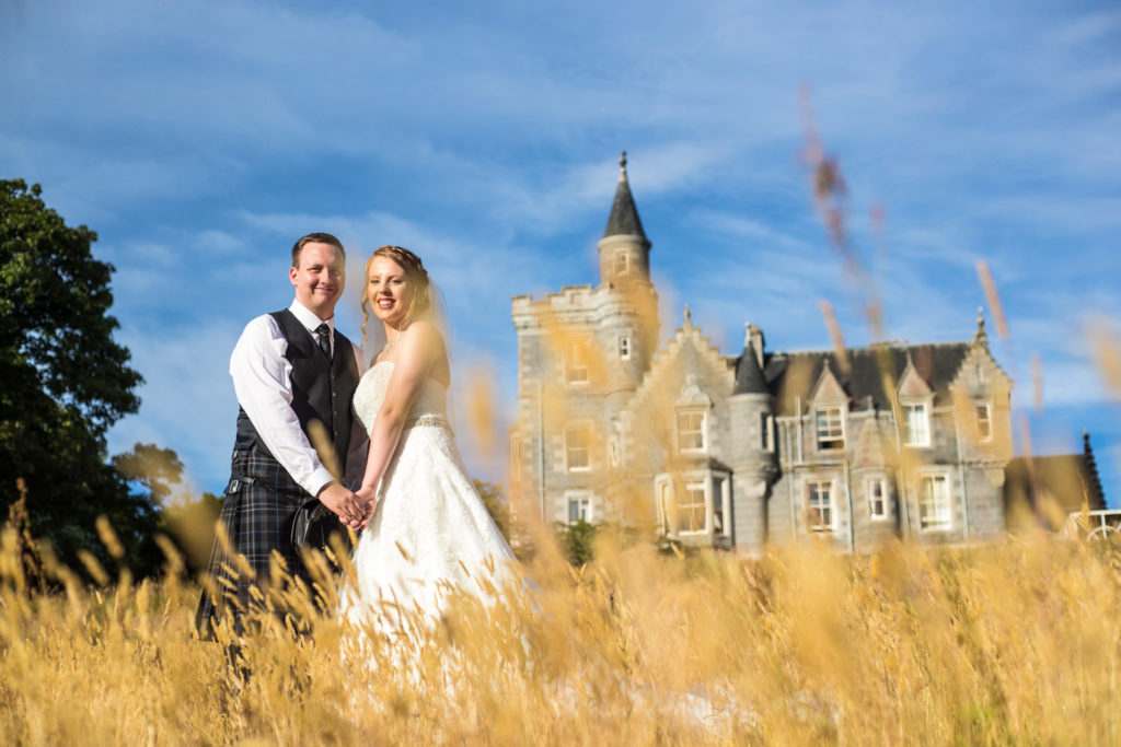 Wedding Photography Aberdeen - A couple pose infant of Ardoe House in a wheat field