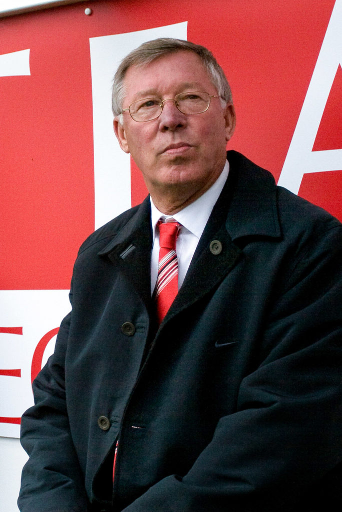 Sir Alex Ferguson sitting on the Substitution bench at Pittodrie Stadium looking over the camera.