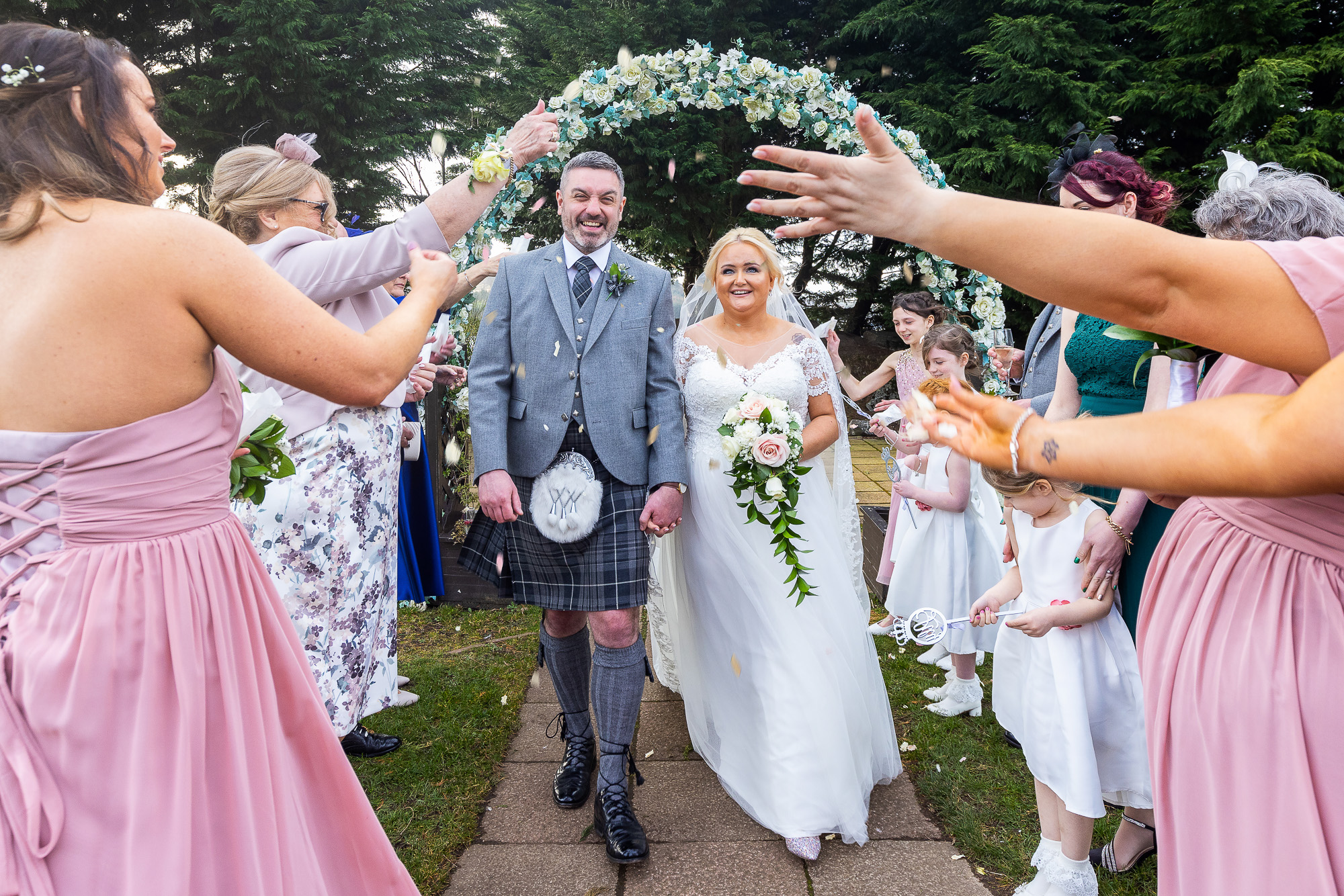 A image of a couple walking up the isle after getting married. Confetti has been thrown towards the couple by guests. Wedding photographer Aberdeen, Picture by Scott Cameron Baxter.