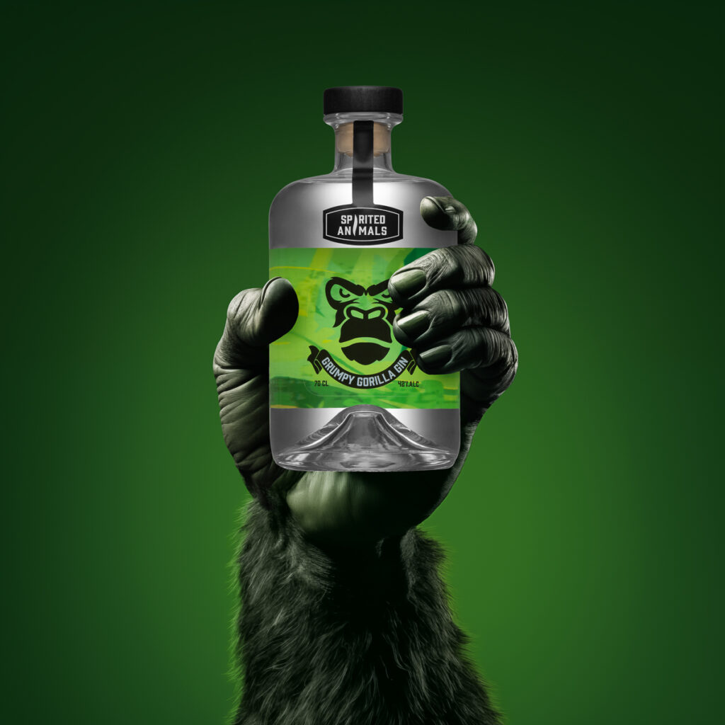 A bottle of gin by Spirited Animals with a green label and background. The bottle is being held in a gorillas hand tightly, on a green backdrop. Photographed by Aberdeen food and drink commercial photographer Scott Cameron Baxter.